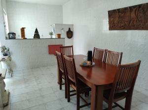 a dining room with a wooden table and chairs at Casa ótima e localização excelente em Aparecida-SP in Aparecida