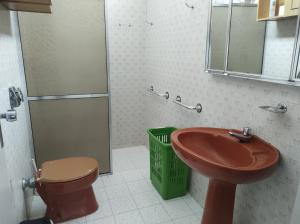 a bathroom with a sink and a toilet and a mirror at Casa ótima e localização excelente em Aparecida-SP in Aparecida