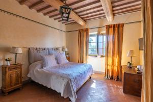 1 dormitorio con cama y ventana grande en Le Ragnaie, en Montalcino