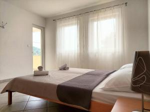 1 dormitorio con 1 cama grande y ventana en Apartments Dia en Zaostrog