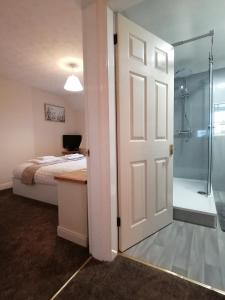 a bedroom with a bed and a shower and a door at Acer Holiday Cottage Tideswell village Buxton Peak District by Rework Accommodation in Tideswell