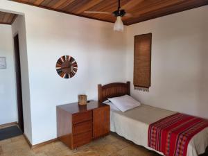 a bedroom with a bed and a clock on the wall at Pousada Ikabana in Pirenópolis