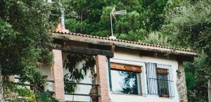 un edificio de ladrillo con una ventana y una turbina eólica en Casa Rural El Zumacal, en Monesterio