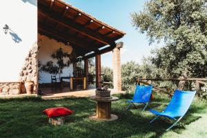 dos sillas azules y una boca de incendios en el césped en Casa Rural El Zumacal, en Monesterio