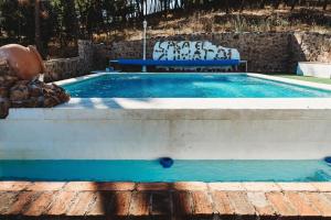 una pequeña piscina con un banco al lado en Casa Rural El Zumacal, en Monesterio