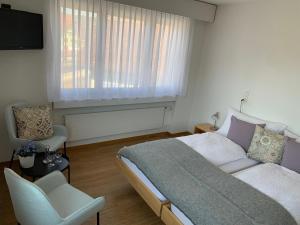 1 dormitorio con 1 cama, 1 silla y 1 ventana en Hotel B&B Stossplatz en Appenzell