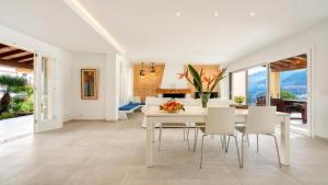 a dining room with a white table and chairs at Apartamento Guillem in Cala de Sant Vicent