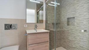 a bathroom with a shower and a sink and a toilet at Apartamento Guillem in Cala de Sant Vicent +20 photos
