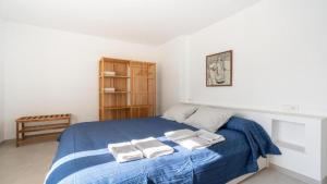a bedroom with a blue bed with two towels on it at Apartamento Guillem in Cala de Sant Vicent