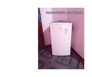 einen weißen Kühlschrank auf dem Boden in einem Zimmer in der Unterkunft Pousada Asa Branca in Soure