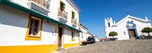 a church with a car parked next to a building at Abetarda CC in São Marcos da Ataboeira