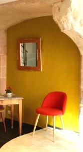 a red chair sitting next to a table with a mirror at L'antre ami in Savigny-lès-Beaune