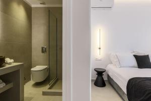 a bedroom with a bed and a bathroom with a toilet at Sunset Windmills Suites in Mýkonos City