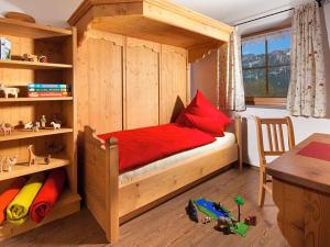 a bedroom with a wooden bunk bed with red sheets at Ferienwohnung Roislerlehen in Bischofswiesen