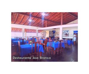 Un comedor con mesas y sillas azules. en Pousada Asa Branca, en Soure