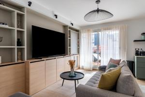 un salon avec un canapé et une télévision dans l'établissement Cours Morny, à Deauville