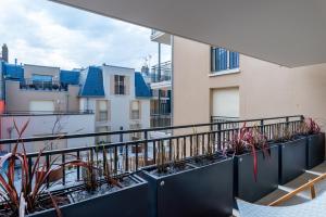 een balkon met planten aan de zijkant van een gebouw bij Cours Morny in Deauville