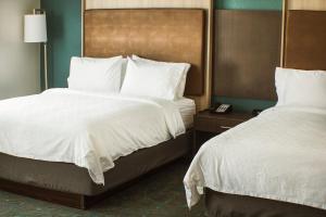 Holiday Inn Cookeville, an IHG Hotel في كوكفل: غرفه فندقيه سريرين بشرشف ابيض