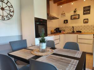 a dining room with a table and chairs and a kitchen at La Tannerie du Port in Dinan