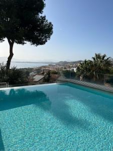una gran piscina azul con vistas al océano en LU&CIA Villa Infinity, en Málaga