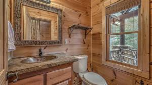 a log cabin bathroom with a sink and a mirror at Bearfoot Lodge in Epworth +54 photos