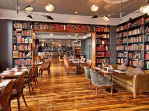 een restaurant met tafels en stoelen en boekenplanken bij The Address Cork (formerly Ambassador Hotel & Health Club) in Cork