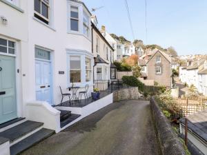 a street view of a white house with a table and chairs at Driftwood in Fowey