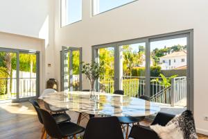 comedor con mesa de cristal y sillas en TheCalming Cactus Cascais en Estoril