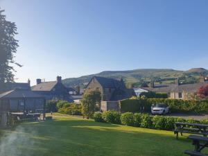 un parco con una panchina, una casa e un'auto di 2 bed period cottage sleeps 4 in central Crickhowell a Crickhowell