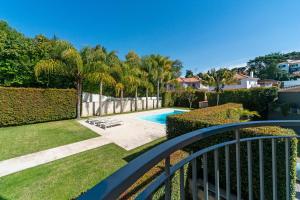 a view from a balcony of a yard with a swimming pool at TheCalming Cactus Cascais in Estoril