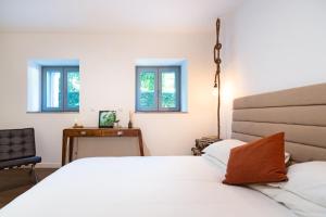 a bedroom with a white bed and two windows at TheCalming Cactus Cascais in Estoril +26 photos
