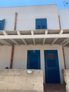 ein Haus mit zwei blauen Türen und zwei Fenstern in der Unterkunft Orsolinda Favignana in Favignana