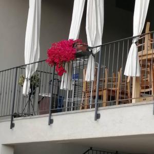 a balcony with a bunch of chairs and flowers on it at Little Family in Salò