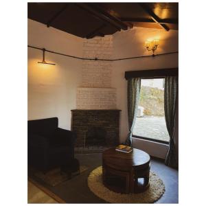 - un salon avec un canapé et une cheminée dans l'établissement Mulberry House, à Almora