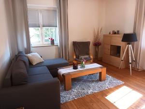 een woonkamer met een blauwe bank en een salontafel bij Ferienwohnung NaumburgLiebe in Naumburg