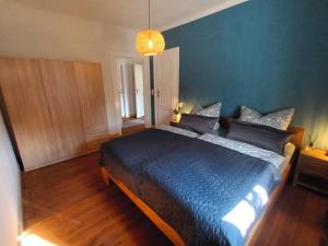 een slaapkamer met een groot bed met een blauwe deken bij Ferienwohnung NaumburgLiebe in Naumburg +26 foto's