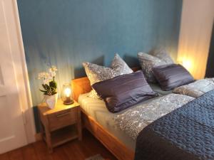 een slaapkamer met een bed met kussens erop bij Ferienwohnung NaumburgLiebe in Naumburg