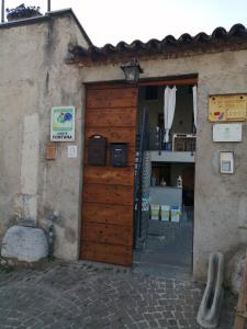 a building with a wooden door and a building with a counter at Little Family in Salò