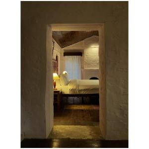 1 dormitorio con 1 cama en una habitación con puerta abierta en Mulberry House en Almora