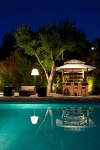 een zwembad met een prieel en een tafel en stoelen bij Benvengudo in Les Baux-de-Provence