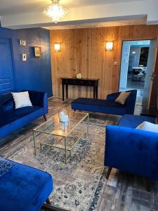 Saint-Michel-Mont-MercureにあるL'hostellerie de Sèvremontのリビングルーム(青いソファ、テーブル付)