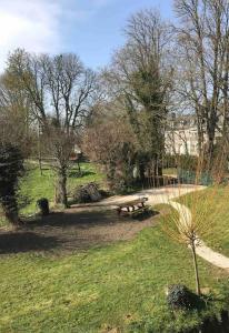 ein Park mit einer Picknickbank im Gras in der Unterkunft Maison au bord de riviere , proche de la mer- spa semi rigide plein air en option in Bacqueville-en-Caux