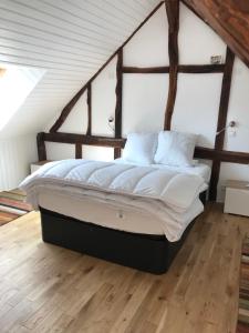 a bedroom with a large bed in a attic at Maison au bord de riviere , proche de la mer- spa semi rigide plein air en option in Bacqueville-en-Caux