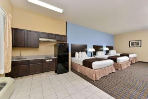 a hotel room with two beds and a kitchen at Western Inn & Suites in Carrizo Springs