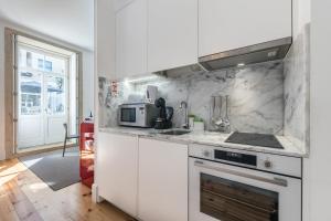 uma cozinha branca com um fogão e um micro-ondas em Backyard Palace Terrace no Porto