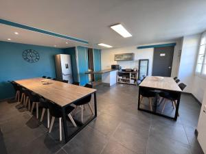 une salle à manger avec deux tables et une cuisine dans l'établissement L'hostellerie de Sèvremont, à Saint-Michel-Mont-Mercure