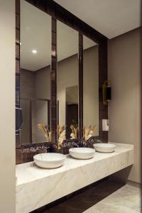 una fila de lavabos en un baño con espejos en Hotel de Turistas Huancayo - Hotel Asociado Casa Andina, en Huancayo