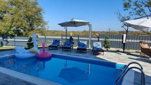 - une piscine avec des chaises et un parasol dans l'établissement Holiday Home Gračec, à Gračec