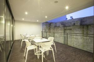 a restaurant with white tables and chairs on a balcony at Casa Dona Maria Luiza in Torre de Moncorvo