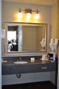 La salle de bains est pourvue d'un lavabo et d'un grand miroir. dans l'établissement Best Western Willows Inn, à Willows